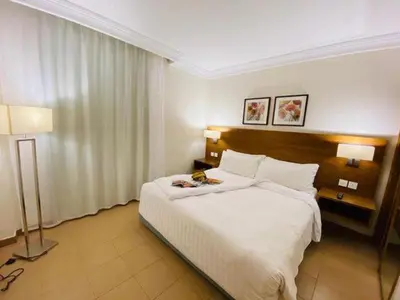 a hotel room with a large bed and two lamps at Hurghada Suites & Apartments Serviced by Marriott in Hurghada