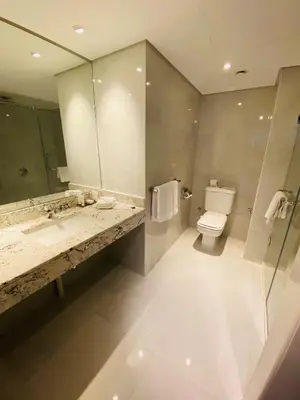 a bathroom with a sink and a toilet and a mirror at Hurghada Suites & Apartments Serviced by Marriott in Hurghada