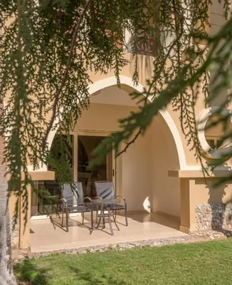 a patio with chairs and a table in a building at Serenity Alpha Beach - Ex Serenity Makadi Beach in Hurghada
