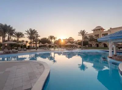a large swimming pool in a resort with palm trees at Serenity Alpha Beach - Ex Serenity Makadi Beach in Hurghada