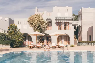 a group of people sitting in a pool in front of a building at Fanadir Hotel El Gouna in Hurghada