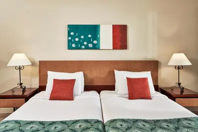 two beds in a hotel room with red pillows at Fanadir Hotel El Gouna in Hurghada