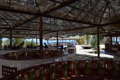 a restaurant with chairs under a straw roof at Mangrove Bay Resort in Quseir