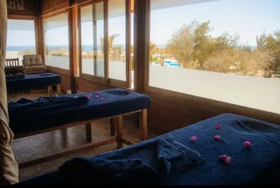 a room with two beds and a large window at Mangrove Bay Resort in Quseir