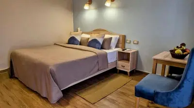 a bedroom with a large bed and a blue chair at Mangrove Bay Resort in Quseir