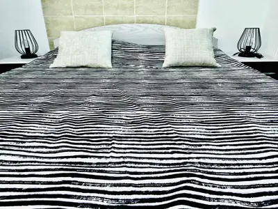 a black and white bed with two pillows on it at Zebra Apartments Hurghada center in Hurghada