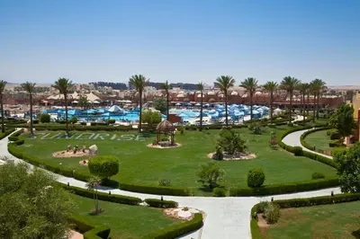 a view of a park with palm trees and swimming pools at Sunrise Royal Makadi Resort in Hurghada