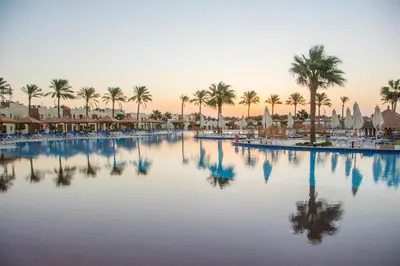 a view of a pool at a resort with palm trees at Sunrise Royal Makadi Resort in Hurghada