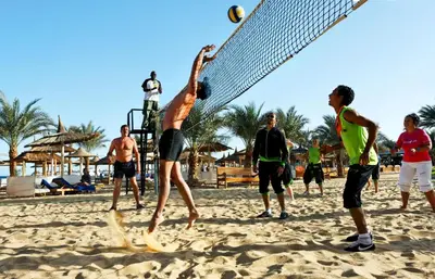 a group of people playing volley ball on the beach at Beach Albatros Aqua Park - Hurghada in Hurghada