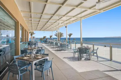 a restaurant on the beach with tables and chairs at Beach Albatros Aqua Park - Hurghada in Hurghada