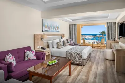 a hotel room with a king sized bed and purple furniture at Beach Albatros Aqua Park - Hurghada in Hurghada