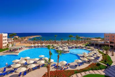 an overhead view of a pool with umbrellas and the ocean at Beach Albatros Aqua Park - Hurghada in Hurghada