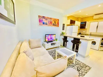 a living room with a couch and a kitchen at Panda Grey with balcony Hurghada center in Hurghada