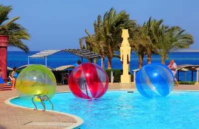 three colorful balls in the pool at a resort at Sphinx Aqua Park Beach Resort in Hurghada