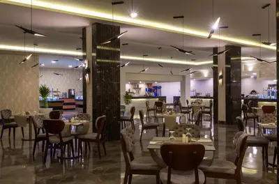 a restaurant with tables and chairs and a bar at Pickalbatros Aqua Blu Resort - Hurghada in Hurghada