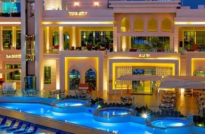 a hotel lobby with a pool and tables and chairs at Pickalbatros Aqua Blu Resort - Hurghada in Hurghada