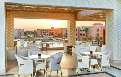 a restaurant with tables and chairs on a balcony at Pickalbatros Aqua Vista Resort - Hurghada in Hurghada