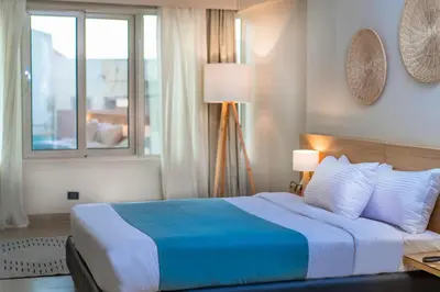 a bedroom with a blue and white bed with a window at Redcon Suites in Hurghada