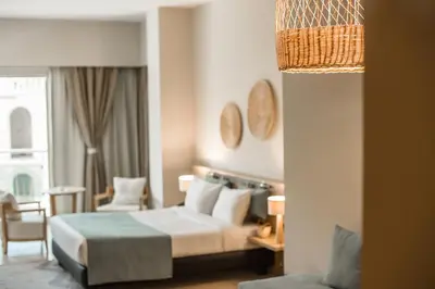 a hotel room with a bed and a chair at Redcon Suites in Hurghada