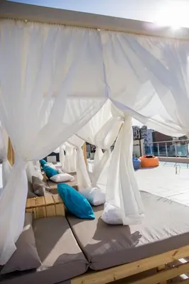 a bed on a boat with white sheets and pillows at Redcon Suites in Hurghada
