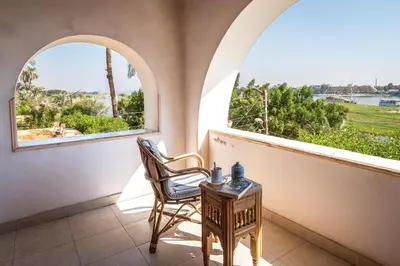 a balcony with two chairs and two windows at villa al diwan luxor in Luxor