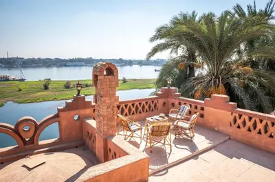a patio with chairs and tables on a balcony at villa al diwan luxor in Luxor