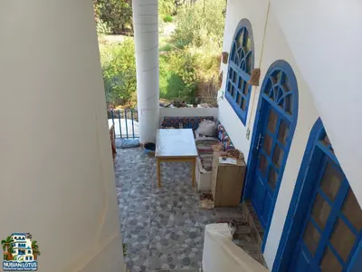 a hallway with blue doors and a table in a house at Nubian Lotus in Aswan