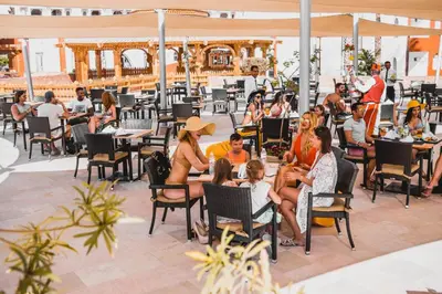 a group of people sitting in chairs at a restaurant at Sunrise Garden Beach Resort in Hurghada