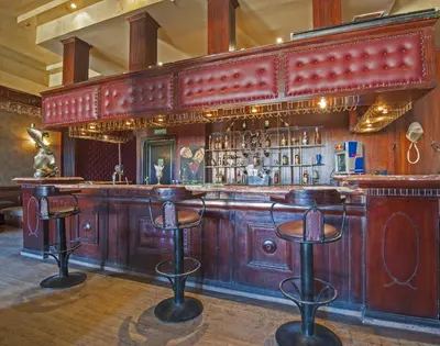 a bar with a wooden counter and bar stools at Sunrise Garden Beach Resort in Hurghada