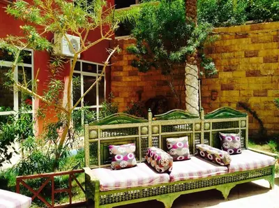 a bench with pillows on it in a garden at Diamond Arabia with Wi Fi in Hurghada