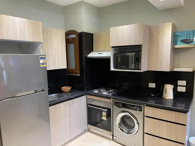 a kitchen with a washer and a microwave and a dishwasher at El Gouna 1 Bedroom Apartment west golf ground floor in Hurghada