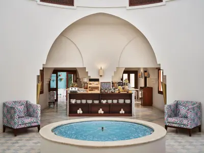 a wellness center with a pool in the middle of a building at Mosaique Hotel El Gouna in Hurghada