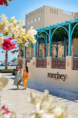 two women walking down a street in front of a building at Mosaique Hotel El Gouna in Hurghada