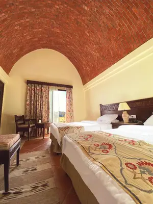 a bedroom with two beds and a brick wall at ONATTI Beach Resort - Marsa Alam in Quseir