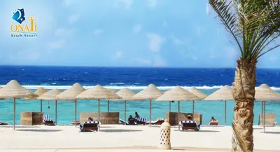 a beach with chairs and umbrellas and the ocean at ONATTI Beach Resort - Marsa Alam in Quseir