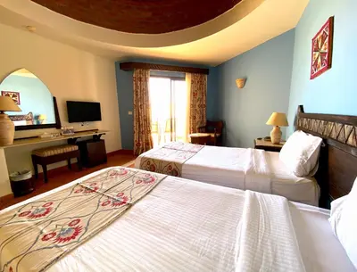 a hotel room with two beds and a tv at ONATTI Beach Resort - Marsa Alam in Quseir