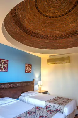 two beds in a hotel room with a ceiling at ONATTI Beach Resort - Marsa Alam in Quseir