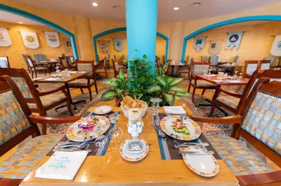 a dining room with a table with plates of food at Sunrise Holidays Resort -Adults Only in Hurghada