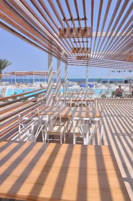 a dining area with tables and chairs and the ocean at Sunrise Holidays Resort -Adults Only in Hurghada