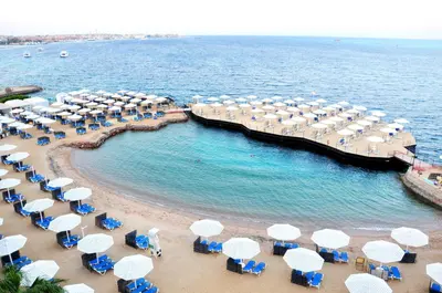 a group of umbrellas and chairs on a beach at Sunrise Holidays Resort -Adults Only in Hurghada