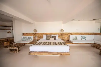 a bedroom with a large bed and two benches at Meraki Resort - Adults Only in Hurghada