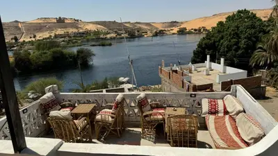 a table and chairs with a view of a river at Seko Kato Nile View Hostel in Aswan
