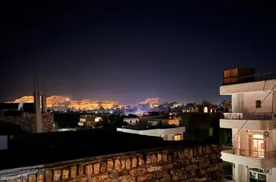a view of a city at night with mountains at House of Dreams apartments Luxor in Luxor