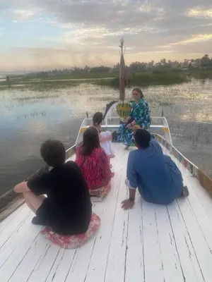 a group of people sitting on a boat on the water at House of Dreams apartments Luxor in Luxor