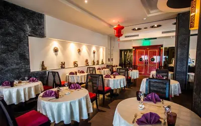 a restaurant with white tables and chairs with purple napkins at Premier Le Reve Hotel & Spa Sahl Hasheesh - Adults Only 16 Years Plus in Hurghada