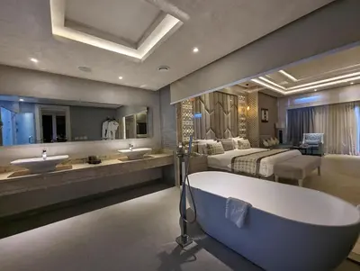 a bathroom with a tub and two sinks and a bed at KaiSol Romance Resort Sahl Hasheesh - Adults Only in Hurghada