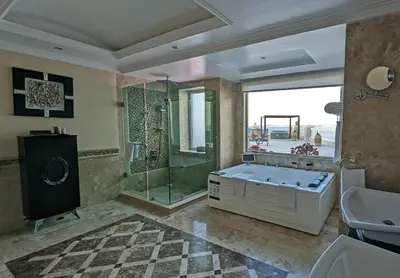 a bathroom with a tub and a shower and a sink at KaiSol Romance Resort Sahl Hasheesh - Adults Only in Hurghada