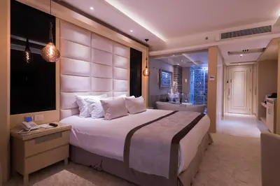 a large bedroom with a large bed and a bathroom at KaiSol Romance Resort Sahl Hasheesh - Adults Only in Hurghada