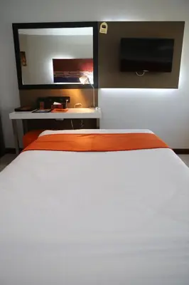 a bedroom with a white bed and a television at Aswan Plaza Hotel in Aswan