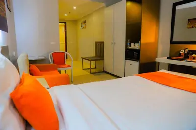 a hotel room with a bed and orange chairs at Aswan Plaza Hotel in Aswan